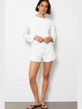 White roll cuff tie waist shorts with adjustable bow front and cuffed hems