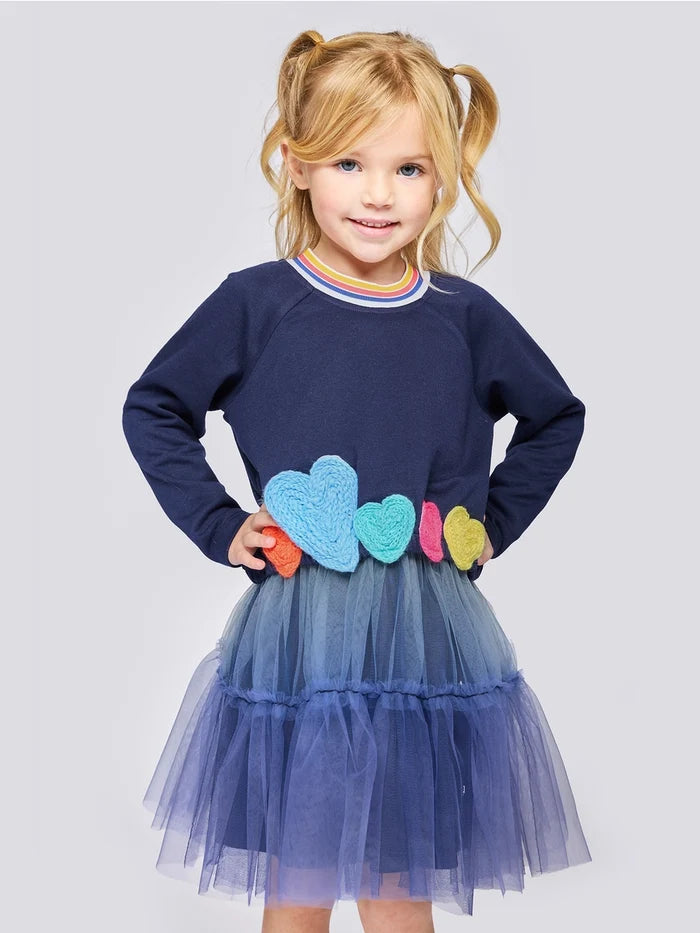 Girl wearing navy long sleeve dress with colorful heart appliques and ombre tulle skirt